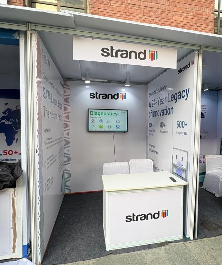 Strand Life Sciences event and conference setup by Ekraft India with branded stall, counter and back-wall graphics