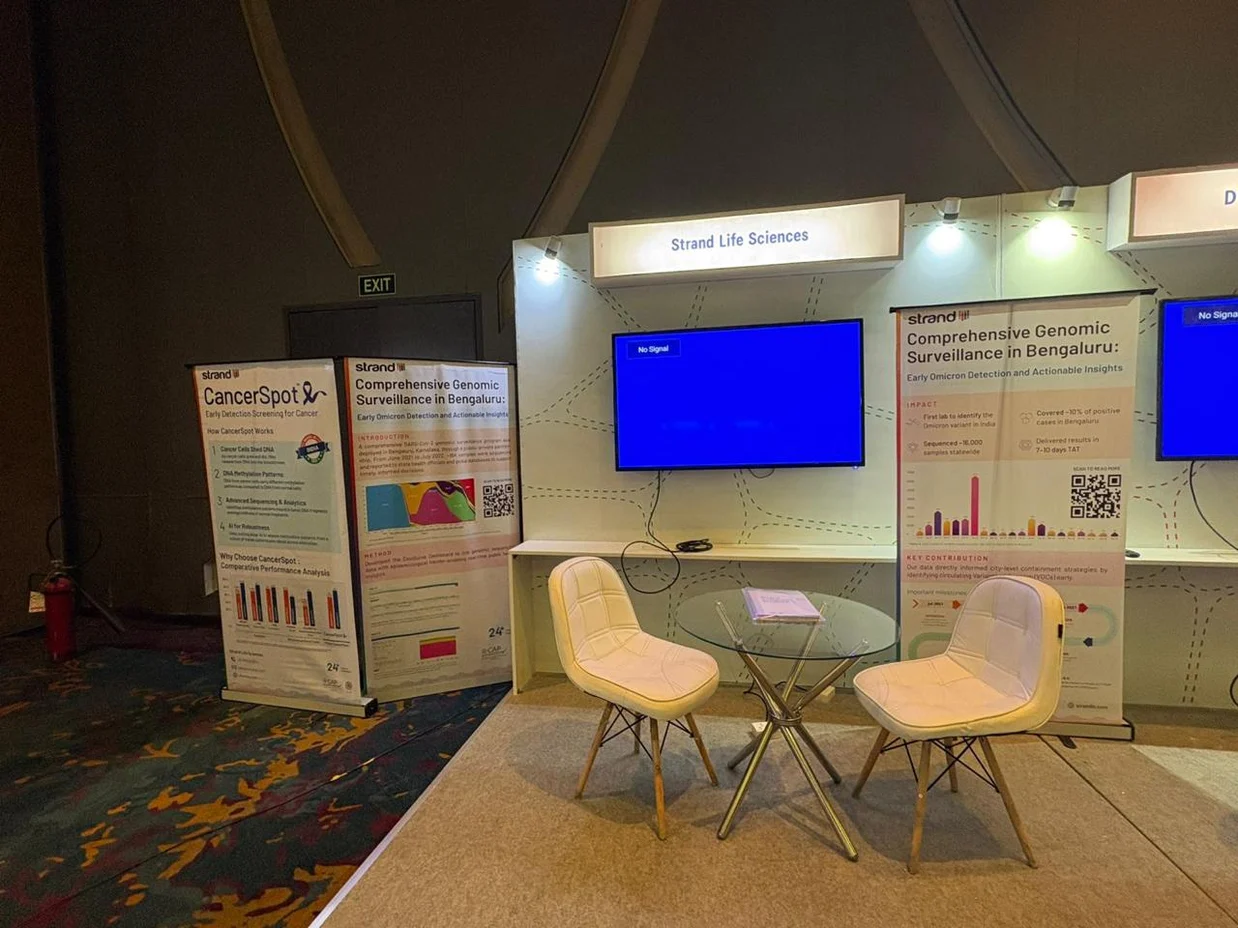 Exhibition stall fabrication and branding by Ekraft India for Strand Life Sciences with standees, back-wall graphics and seating